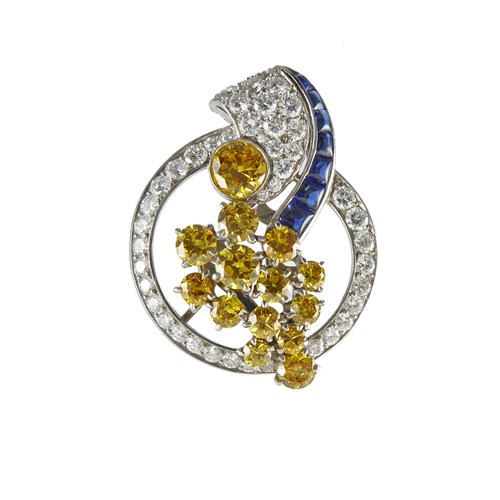 Yellow and white diamond and sapphire circle with scroll brooch, probably American, designed as a diamond circle framing a stylised cornucopia,